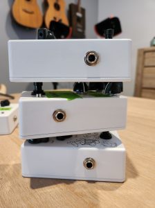 Three guitar pedals stacked on top of each other.